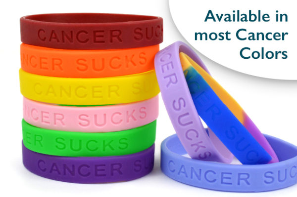 Silicone Wristbands with the Cancer Sucks® phrase embossed on the wristband. Several colors of the wristbands are shown in the image stacked on top of one another.