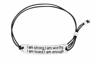 black bracelet with silver pendant reading "I am strong, I am worthy, I am loved, I am enough"