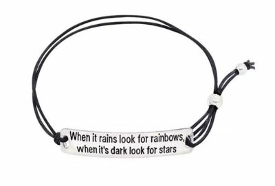 black bracelet with silver charm reading "When it rains look for rainbows, when it's dark look for stars"