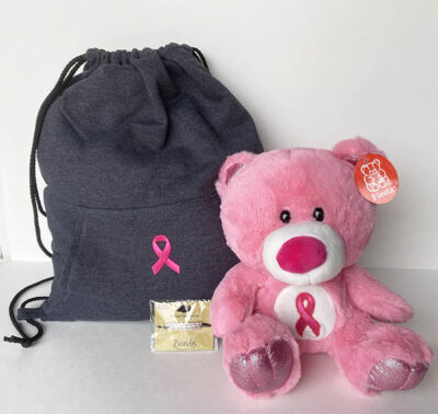 gift set of pink cancer ribbon, with a dark gray draw string bag, pink teddy bear and bracelet