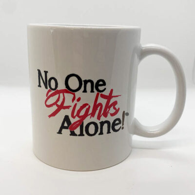 white coffee mug with big black text reading "No One Fights Alone!" with "Fights" being in pretty red text