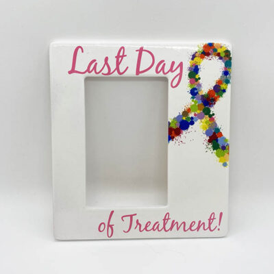 white picture frame with pink text reading "Last day of treatment!" with a multicolored paint ball designed ribbon on the side