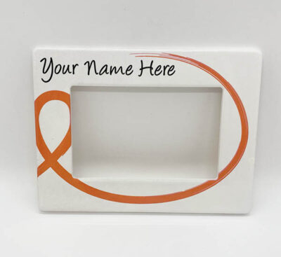 white picture frame with orange ribbon and black text reading "Your name here" on the top