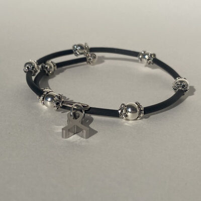 cross wrapped bracelet with metal beads and a metal cancer ribbon charm