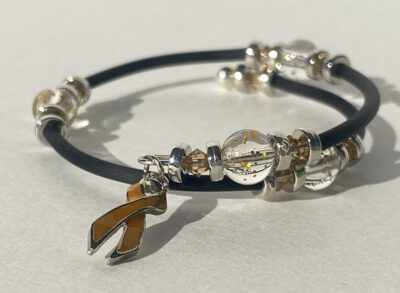 bracelet that crosses itself with big sparkle beads and a burnt orange cancer charm on one end