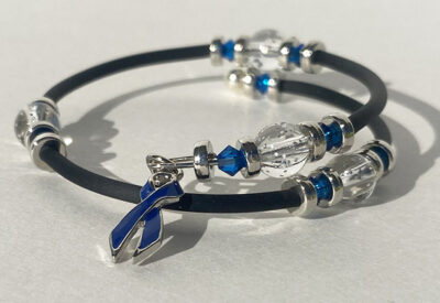 bracelet that crosses itself with big sparkle beads and a dark blue cancer charm on one end