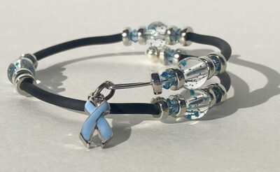 bracelet that crosses itself with big sparkle beads and a periwinkle cancer charm on one end