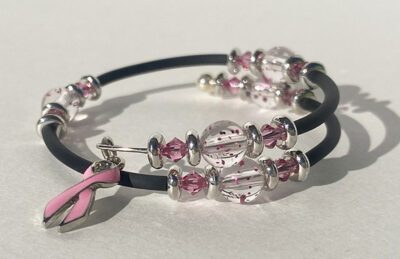 bracelet that crosses itself with big sparkle beads and a pink cancer charm on one end