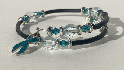 bracelet that crosses itself with big sparkle beads and a blue cancer charm on one end