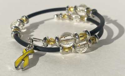 bracelet that crosses itself with big sparkle beads and a yellow cancer charm on one end