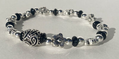 floral metal bracelet with black cancer ribbon charm in the middle