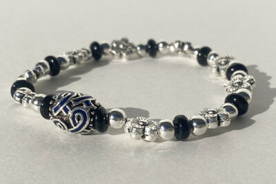 floral metal bracelet with black cancer ribbon charm in the middle