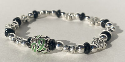 floral metal bracelet with green cancer ribbon charm in the middle