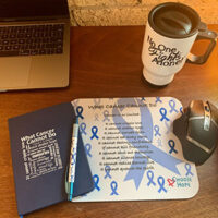 work gift set including the blue cancer ribbon computer mouse pad, pen, coffee travel mug, the computer mouse pad says "what cancer cannot do" and lists everything