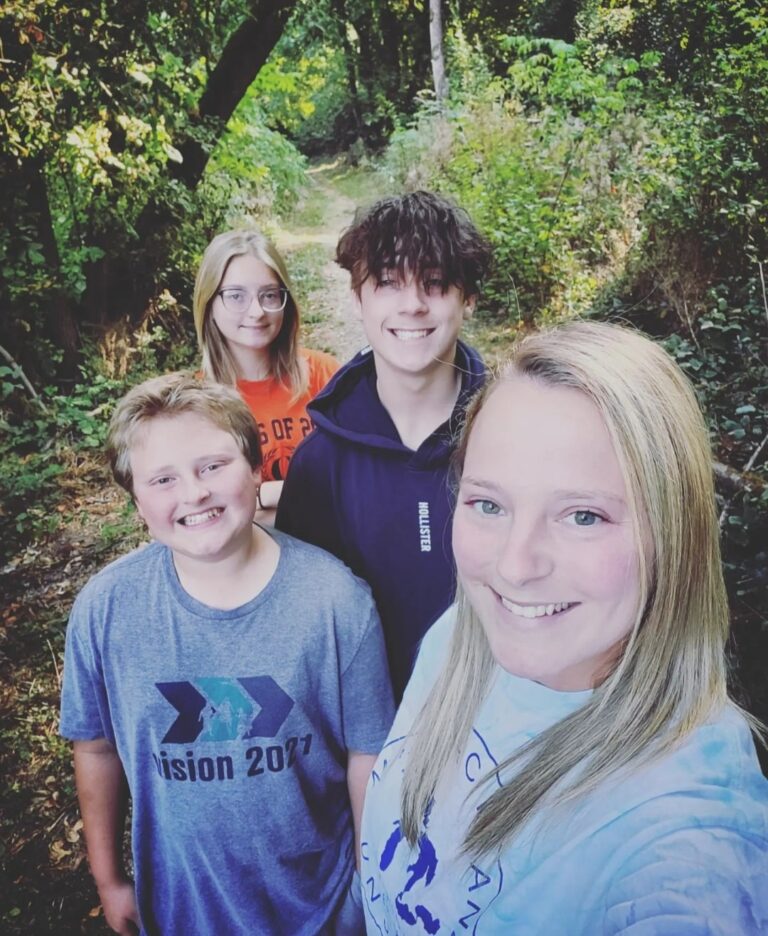 Woman taking a selfie outside with three children