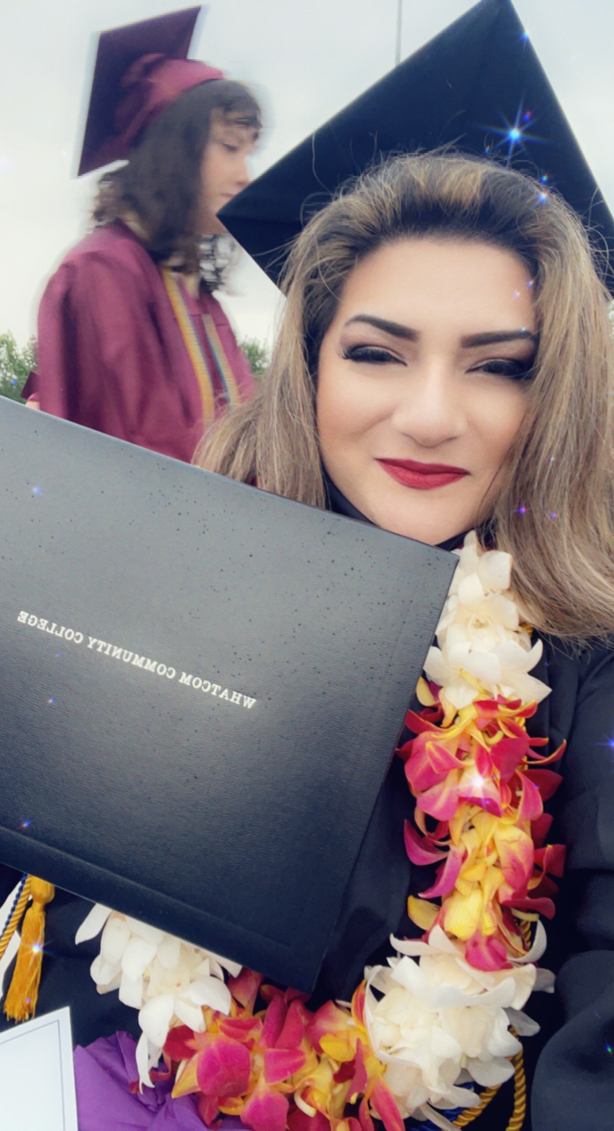 Selfie of a woman graduating college, holding diploma