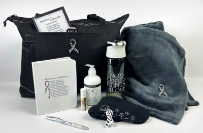 gift set with zebra stripe ribbon: tote bag, blanket, No one fights alone water bottle, lotion and "What Cancer cannot do notebook, cancer awareness ribbon keychain and black fuzzy socks