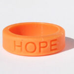 Silicone HOPE ring in Orange color with the word "HOPE" debossed on the ring.