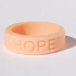 Silicone HOPE ring in Peach color with the word "HOPE" debossed on the ring.