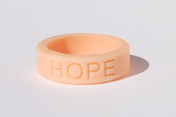 Silicone HOPE ring in Peach color with the word "HOPE" debossed on the ring.