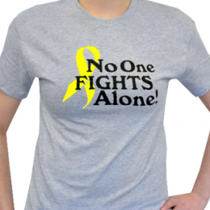 Group image showing our No One Fights Alone® T-shirt that has the wording "No One Fights Alone!" and a cancer awareness ribbon printed on the front of the t-shirt which is a light heather grey color.