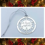 image showing our 'Season of Hope 2025 holiday ornament' in silver finish. Each ornament is laser cut with the wording, "A Season of Hope" in the center and a snowflake pattern connecting to an outer circle that has the year, 2025, with the words, "CHOOSE HOPE" at the bottom of the ornament.